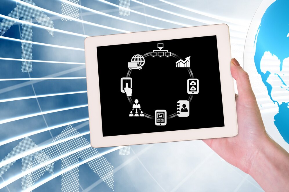 A hand holding a tablet displaying icons representing connectivity